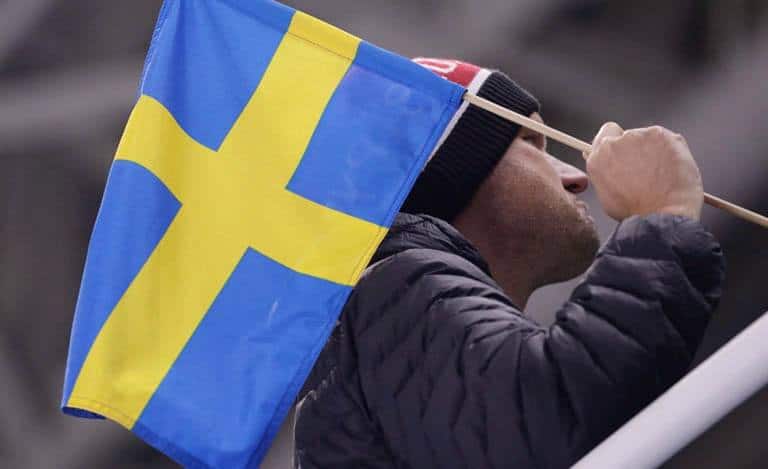 A man holding a New Zealand flag at a football match